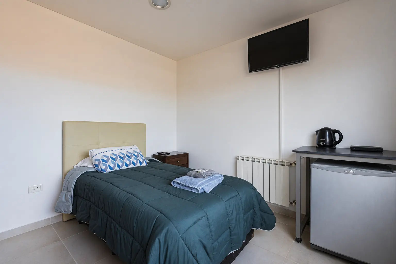 Habitación individual con cama, escritorio y Smart TV.