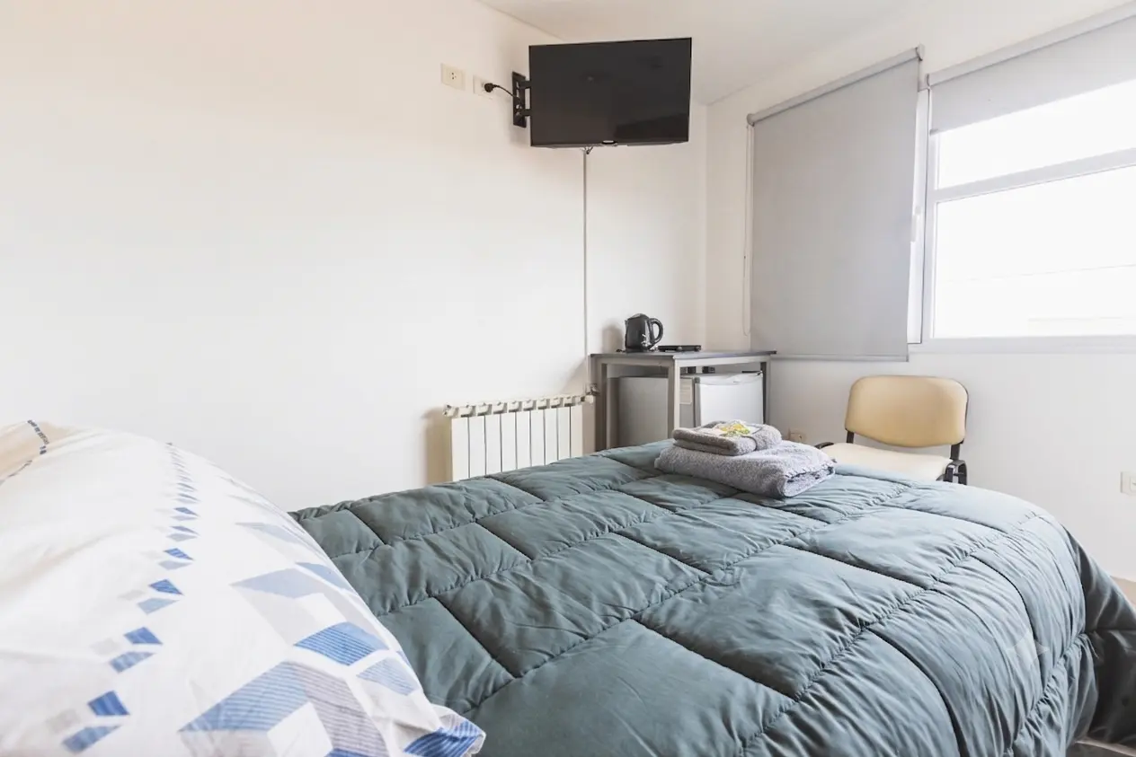 Habitación individual con cama, escritorio y Smart TV.